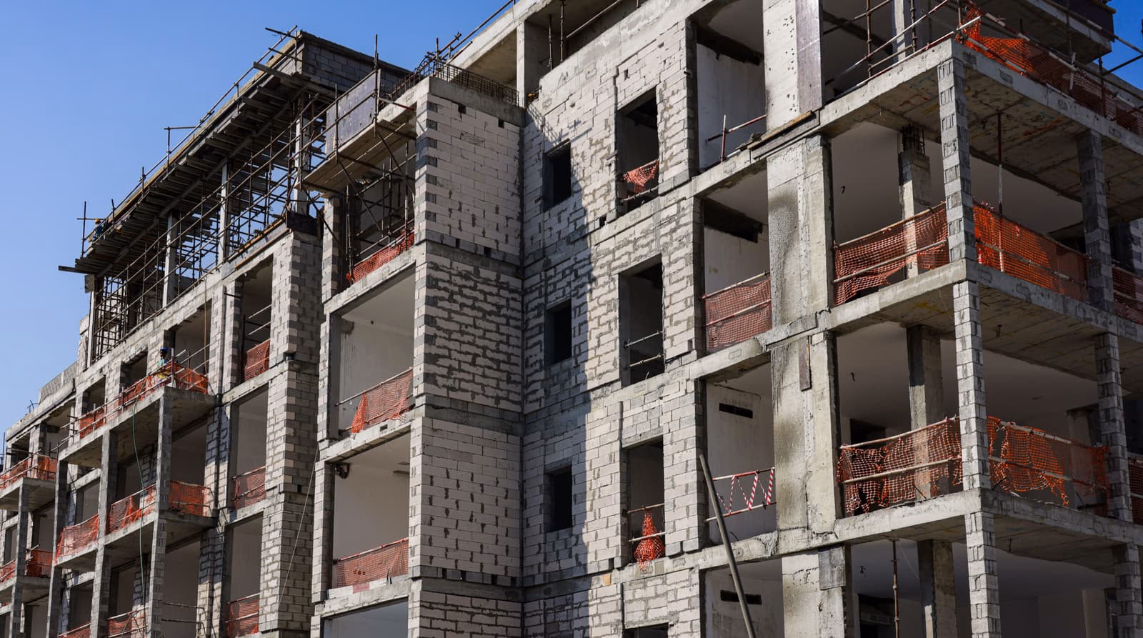 Edificio en construcción con andamios y red de protección